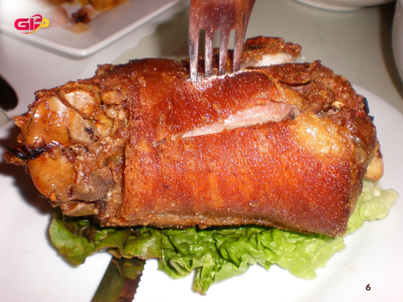 Món đùi lợn chiên giòn và ăn kèm với nước sốt ngâm giấm đậu nành với tỏi và ớt xắt nhỏ.